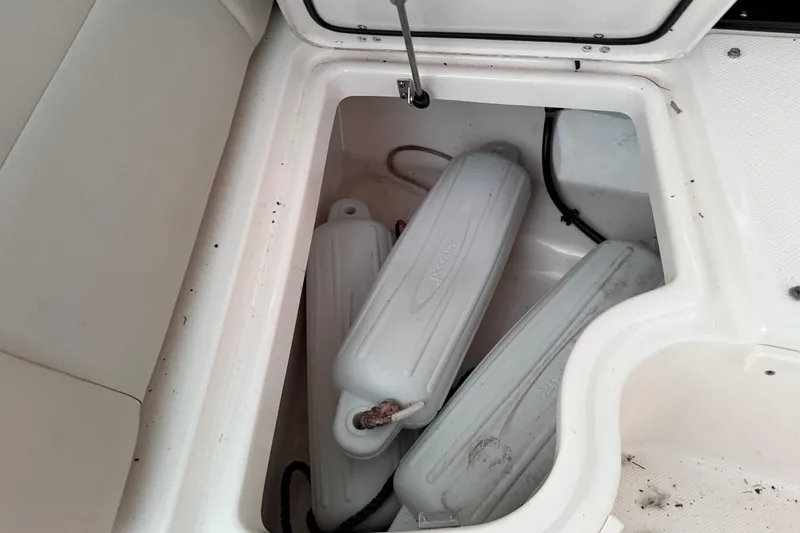 Slide: The Image of Storage compartment with boat fenders on a 2016 Boston Whaler 270 Vantage. - 18
