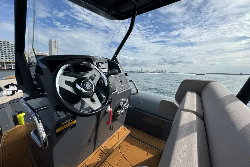 Slide: The Image of Interior view of 2026 Northstar Orion 8 boat with steering wheel and waterfront skyline. - 22