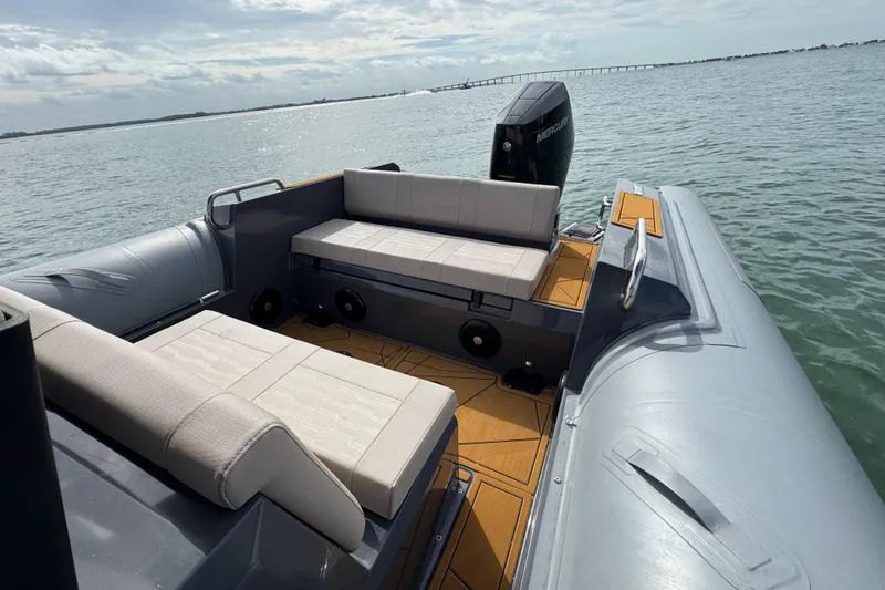 Slide: The Image of 2026 Northstar Orion 8 boat interior with cushioned seating, on calm water. - 26