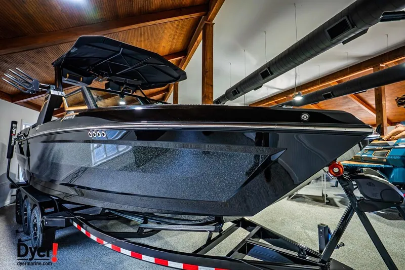 Slide: The Image of 2026 MasterCraft XStar 25 boat in showroom, sleek black design, on trailer. - 3