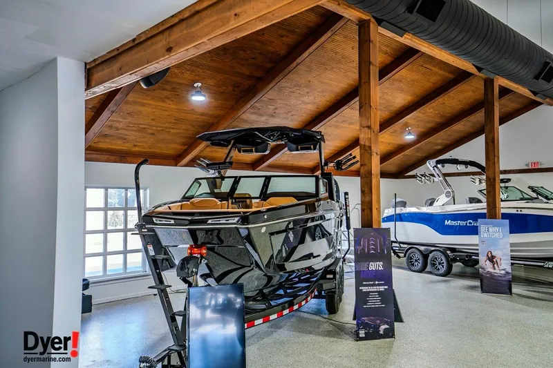 Slide: The Image of 2026 MasterCraft XStar 25 boat displayed in a showroom with wooden ceiling. - 4