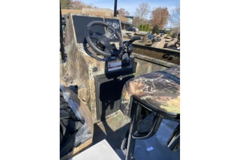 Slide: The Image of 2026 G3 Bay 19 GX boat interior with camo seat and steering console. - 8