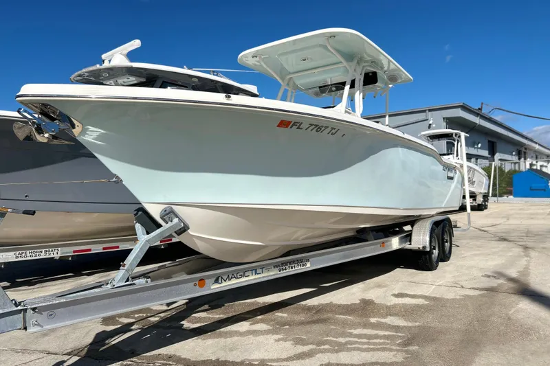 The Image of 2023 Key West 263 FS boat on trailer, parked outdoors under clear blue sky. - 1