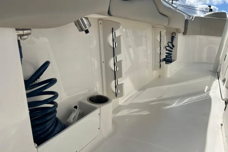 Slide: The Image of 2023 Key West 263 FS boat interior with coiled hoses and cup holder. - 23