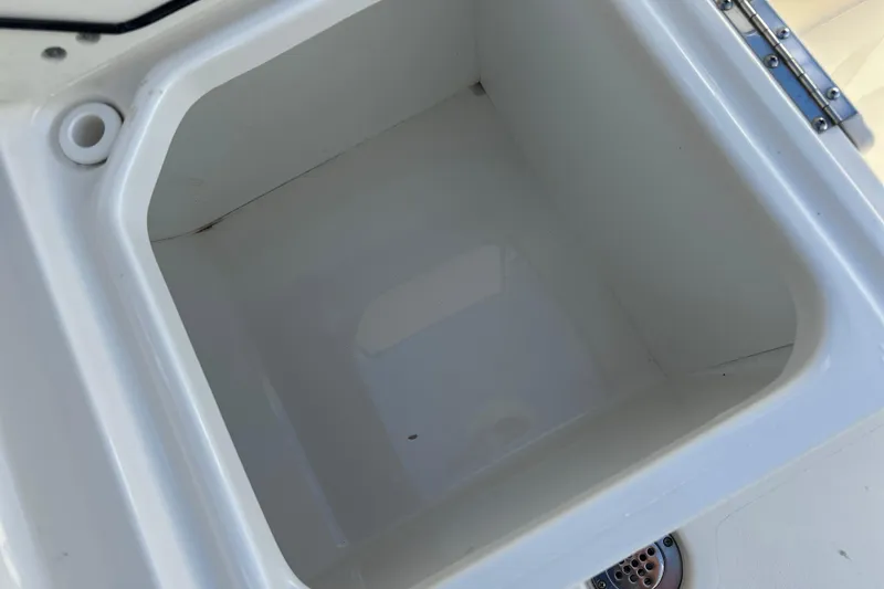 Slide: The Image of 2023 Key West 263 FS boat storage compartment, white interior, open lid. - 35