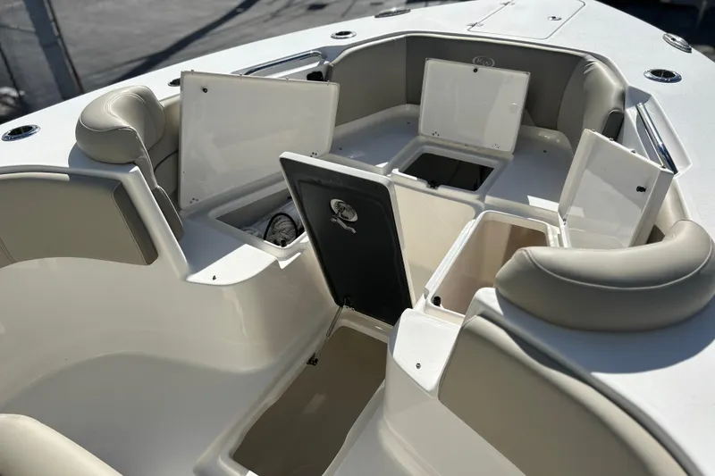 Slide: The Image of 2023 Key West 263 FS boat interior with open storage compartments and cushioned seating. - 40