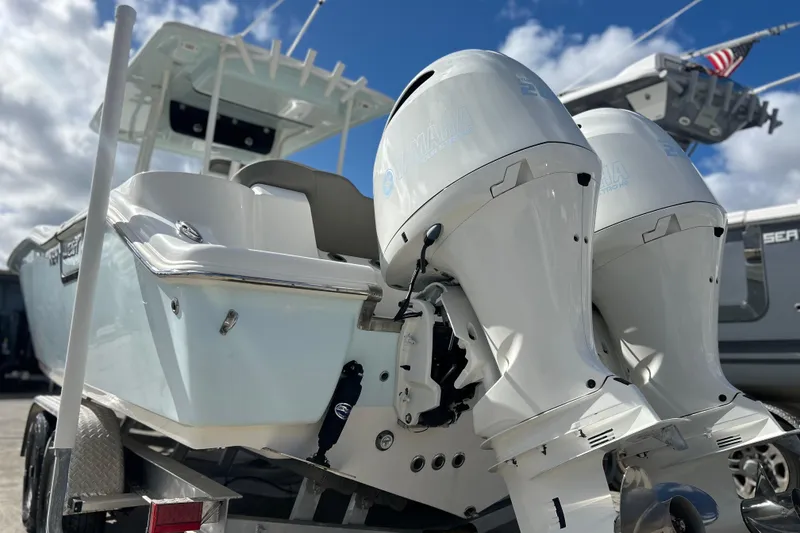 Slide: The Image of 2023 Key West 263 FS boat with dual outboard engines on a trailer. - 43