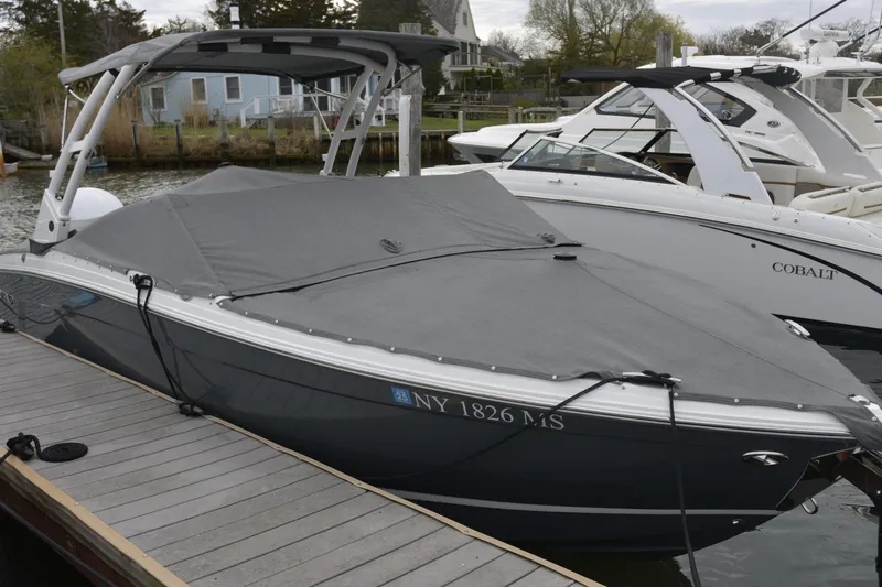 Slide: The Image of 2022 Cobalt R6 Outboard boat docked with cover, side view. - 26