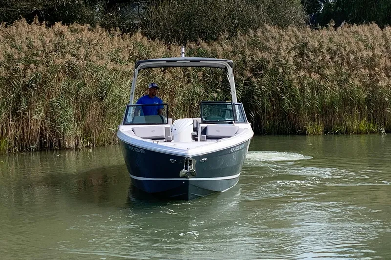 Slide: The Image of 2022 Cobalt R6 Outboard boat navigating a narrow waterway surrounded by reeds. - 4