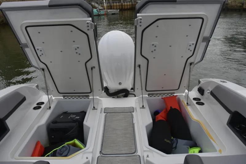 Slide: The Image of 2022 Cobalt R6 Outboard boat storage compartments open, revealing life jackets and gear. - 6