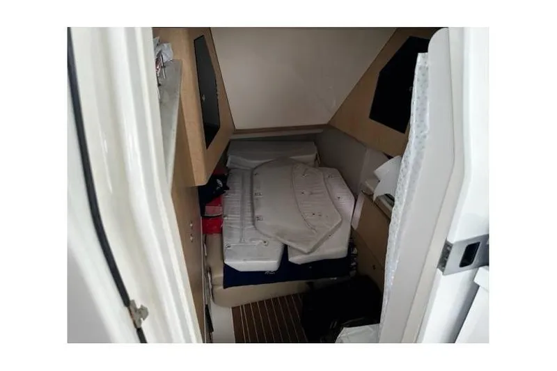 Slide: The Image of Interior cabin of a 2014 Boston Whaler 370 Outrage, featuring a compact sleeping area. - 10