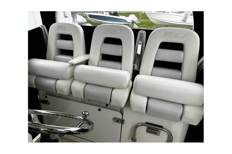 Slide: The Image of 2014 Boston Whaler 370 Outrage interior seating with white cushioned seats and steering wheel. - 3