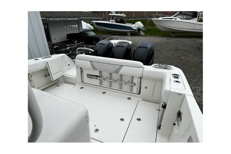 Slide: The Image of 2014 Boston Whaler 370 Outrage boat with triple engines, docked outdoors. - 4