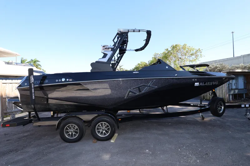 Slide: The Image of 2025 ATX Surf Boats 22 Type-S on trailer, sleek black design, parked outdoors. - 11