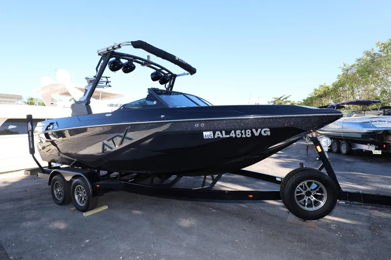 Slide: The Image of 2025 ATX Surf Boats 22 Type-S on trailer, sleek black design, parked outdoors. - 12