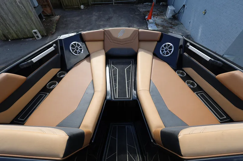 Slide: The Image of 2025 ATX Surf Boats 22 Type-S interior with tan and black seating, cup holders, and speakers. - 22