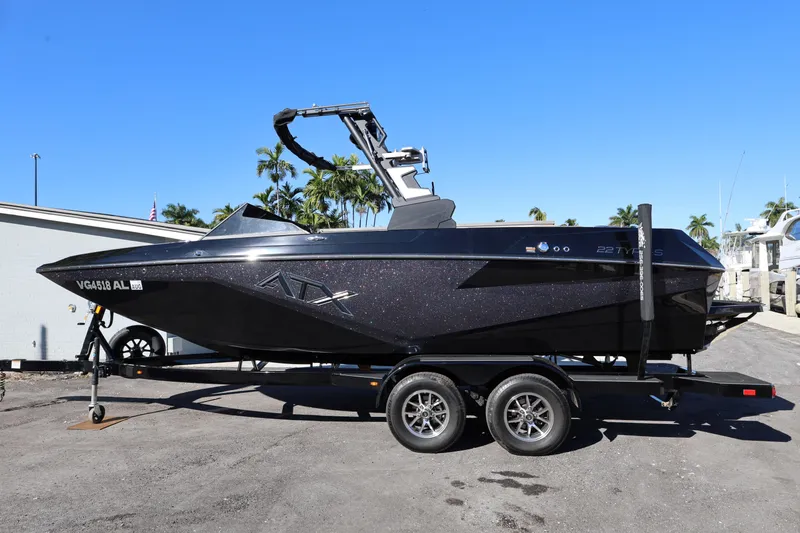 Slide: The Image of 2025 ATX Surf Boats 22 Type-S on trailer, sleek black design, sunny day backdrop. - 3