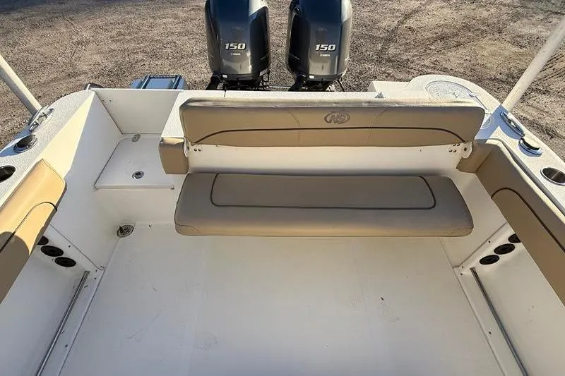 Slide: The Image of 2019 NauticStar 25 XS boat interior with dual 150 engines, beige seating. - 10