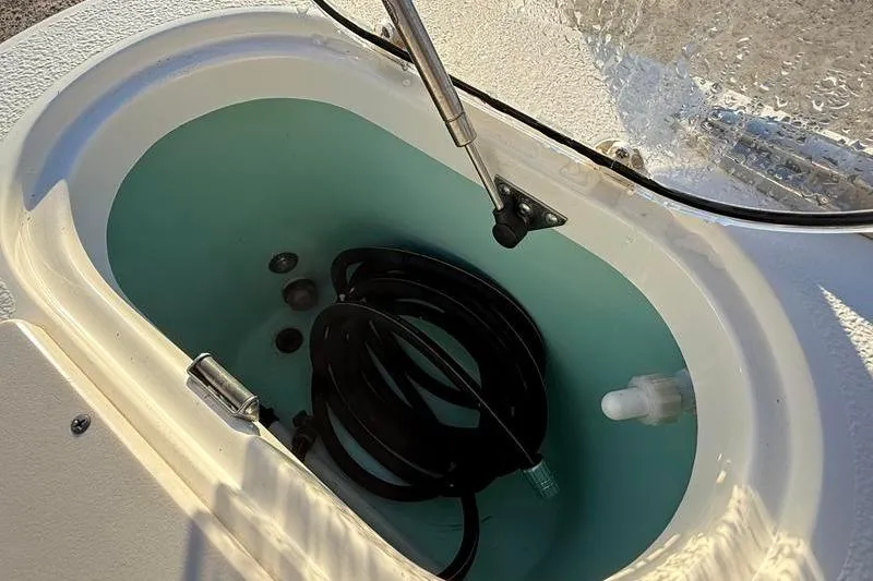 Slide: The Image of Livewell compartment in 2019 NauticStar 25 XS boat with coiled hose. - 12