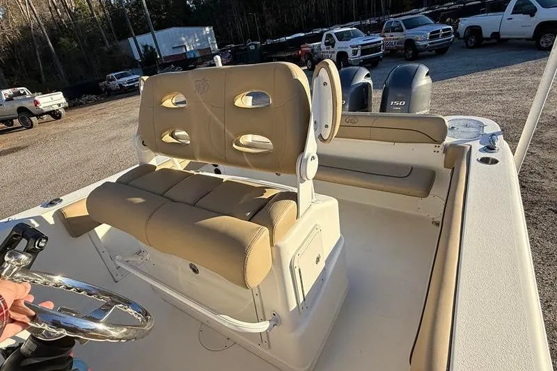 Slide: The Image of 2019 NauticStar 25 XS boat interior with tan seating and dual engines. - 13