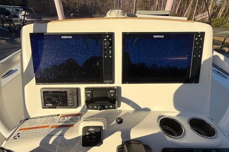 Slide: The Image of 2019 NauticStar 25 XS boat dashboard with dual Simrad displays and controls. - 17