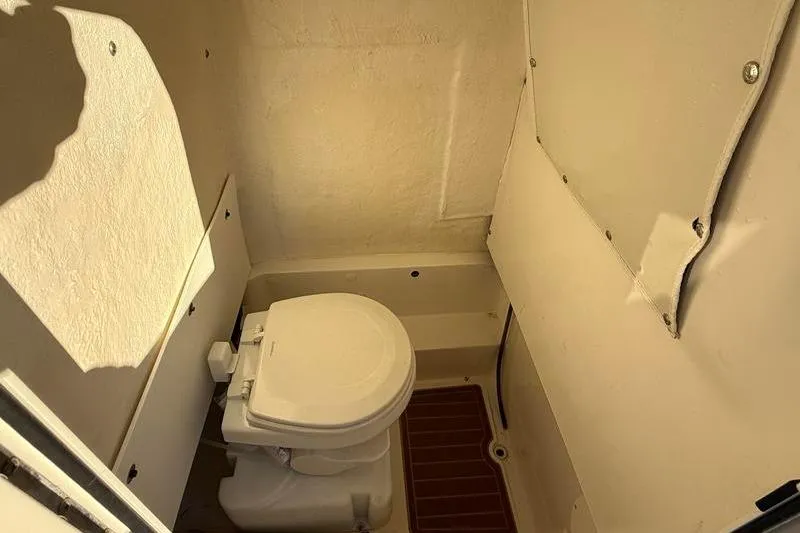 Slide: The Image of 2019 NauticStar 25 XS boat interior with compact marine toilet. - 21