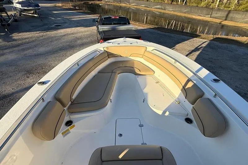 Slide: The Image of 2019 NauticStar 25 XS boat with spacious seating, parked near a waterway. - 22
