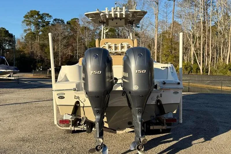 Slide: The Image of 2019 NauticStar 25 XS boat with dual Yamaha 150 engines, parked outdoors. - 3