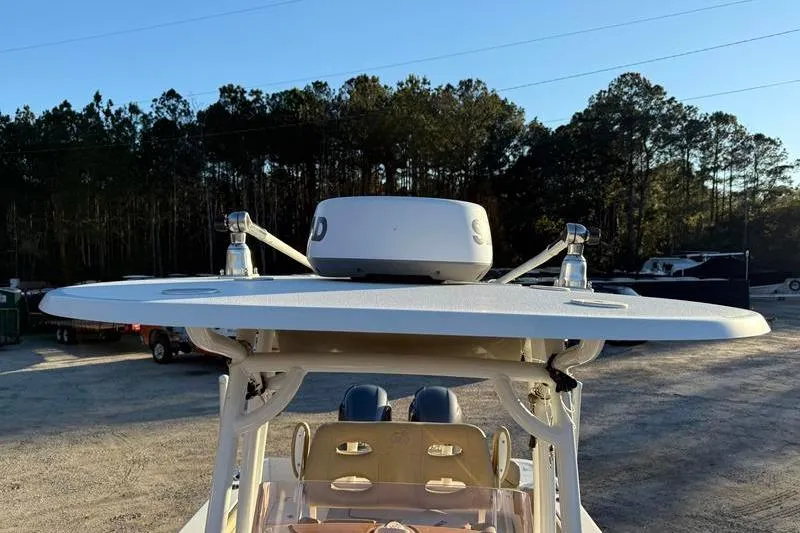 Slide: The Image of 2019 NauticStar 25 XS boat with radar, parked outdoors near trees. - 30