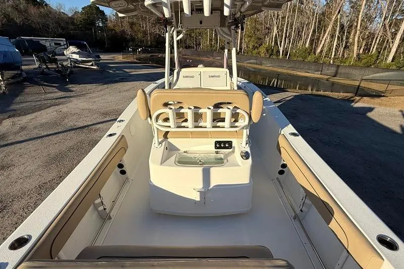 Slide: The Image of 2019 NauticStar 25 XS boat interior with seating and console, parked outdoors. - 8