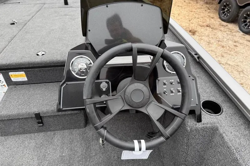 Slide: The Image of 2026 Lowe Stinger 195 Bass boat dashboard with steering wheel and control panel. - 9