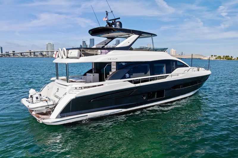 Slide: The Image of 2021 Azimut Fly 78 yacht cruising on blue waters with city skyline backdrop. - 1