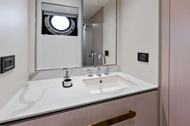 Slide: The Image of Luxurious bathroom interior of 2021 Azimut Fly 78 yacht with modern sink and porthole window. - 79