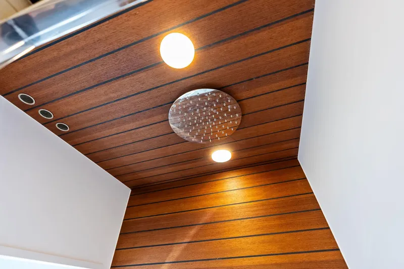 Slide: The Image of Wood-paneled ceiling with recessed lighting and showerhead on 2021 Azimut Fly 78 yacht. - 91