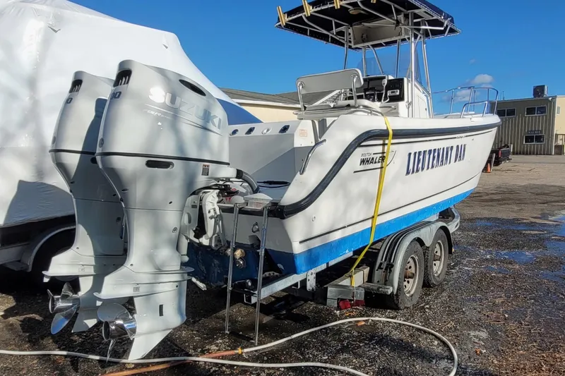 Slide: The Image of 1999 Boston Whaler 26 Outrage boat on trailer with dual Suzuki outboard motors. - 1