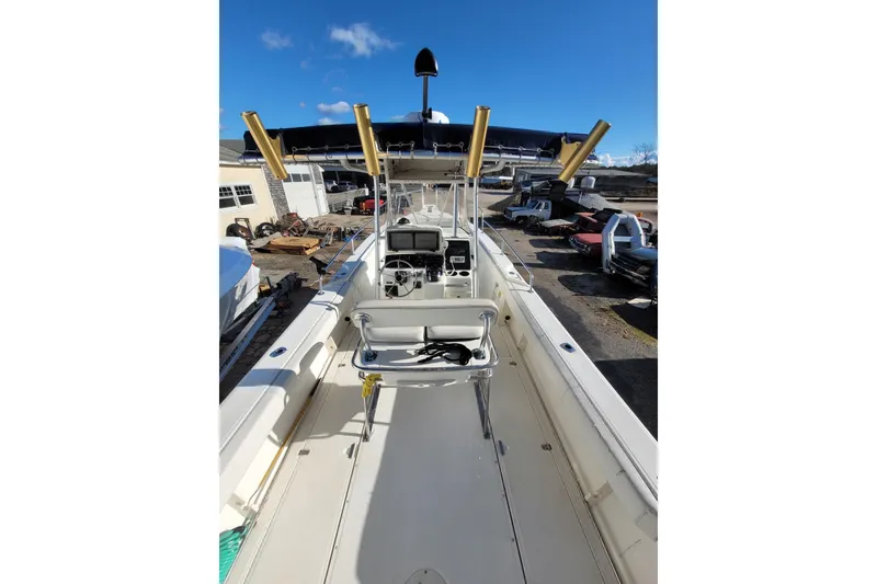 Slide: The Image of 1999 Boston Whaler 26 Outrage boat interior with steering console and rod holders. - 4