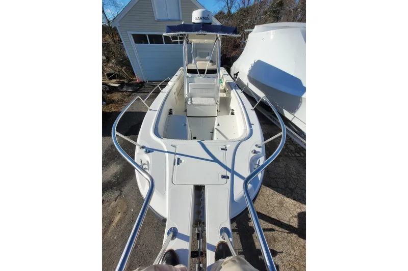 Slide: The Image of 1999 Boston Whaler 26 Outrage boat, docked, with open deck and canopy. - 7