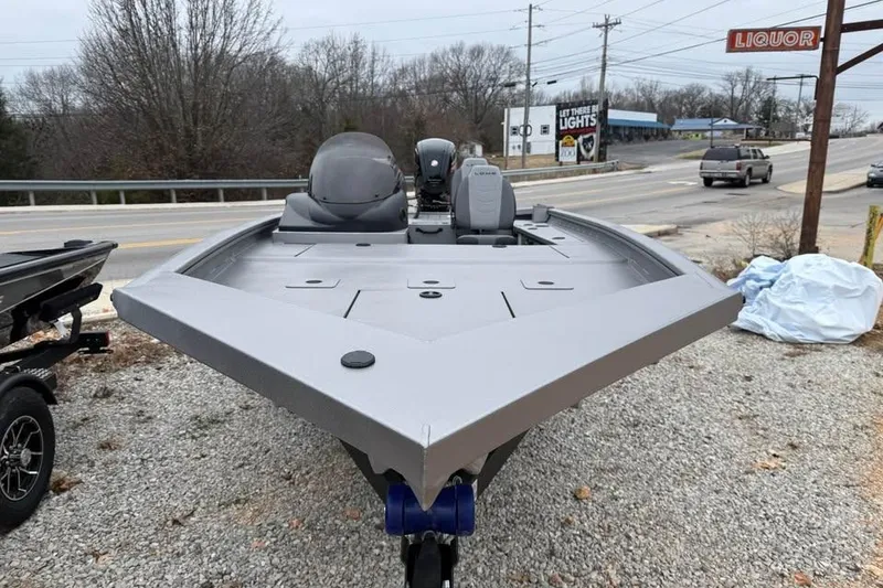 Slide: The Image of 2026 Lowe Outlet 20 boat on gravel near roadside, featuring sleek design and modern outboard motor. - 2