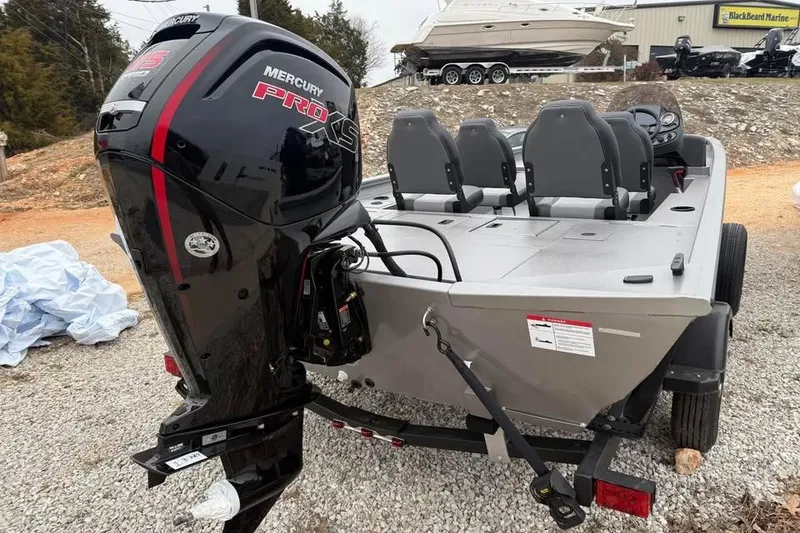 Slide: The Image of 2026 Lowe Outlet 20 boat with Mercury Pro XS engine, parked on gravel. - 5