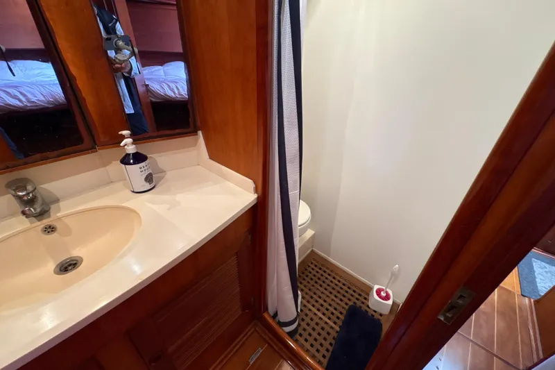 Slide: The Image of 2001 North Wind 56 yacht bathroom with sink, mirror, and shower area. - 21