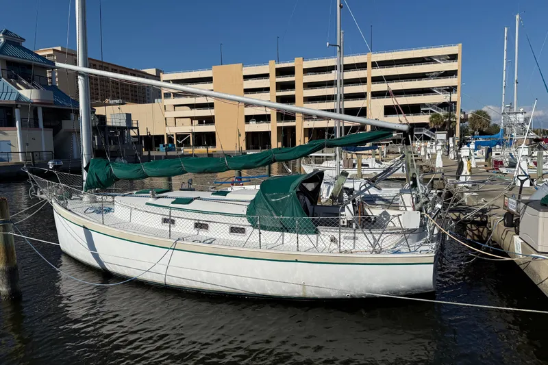 The Image of 1989 Nonsuch 30 Ultra sailboat docked at marina with green covers. - 1