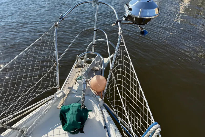 Slide: The Image of Bow of 1989 Nonsuch 30 Ultra sailboat with netting and grill on calm water. - 19