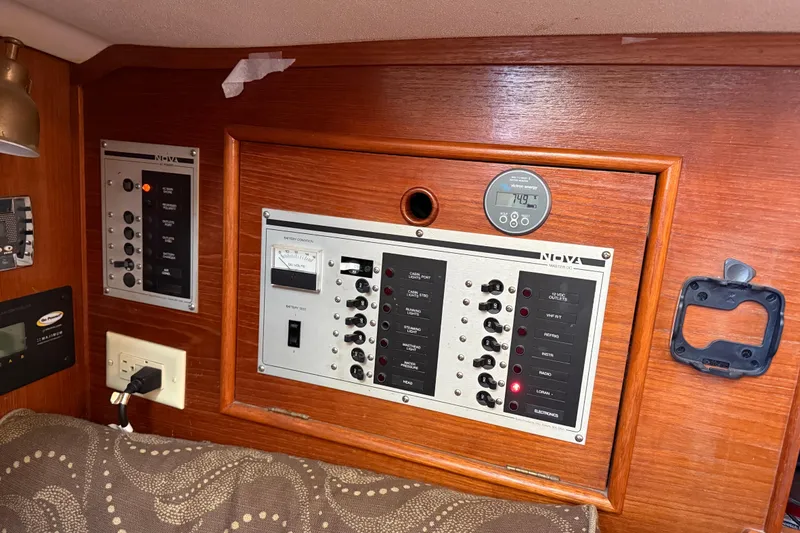 Slide: The Image of Electrical panel inside a 1989 Nonsuch 30 Ultra sailboat, featuring various switches and gauges. - 21