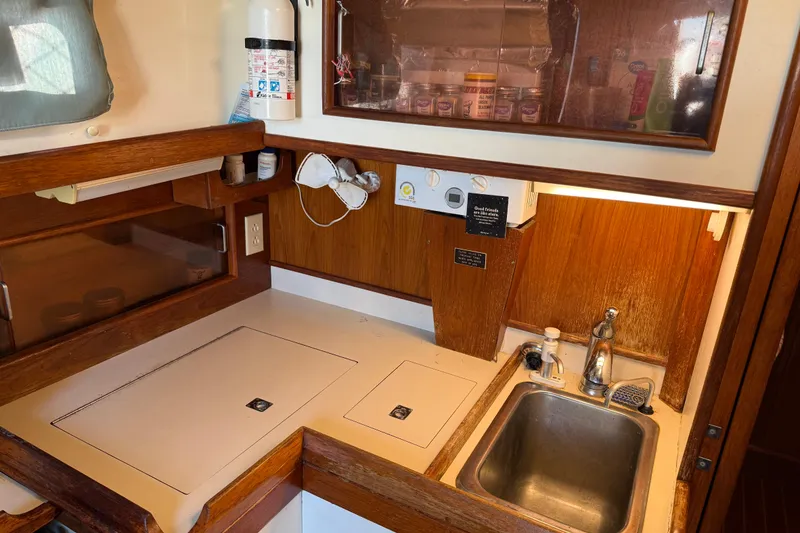 Slide: The Image of Compact kitchen area in a 1989 Nonsuch 30 Ultra sailboat with sink and storage. - 23