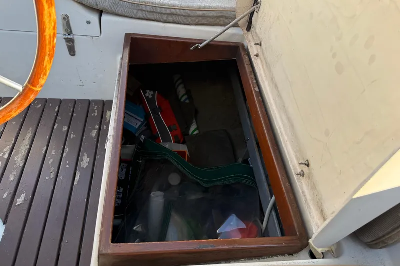 Slide: The Image of Storage compartment on 1989 Nonsuch 30 Ultra sailboat, open with various items inside. - 32