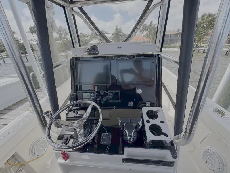 Slide: The Image of 2004 Intrepid 32 Cuddy boat helm with steering wheel and navigation controls. - 11