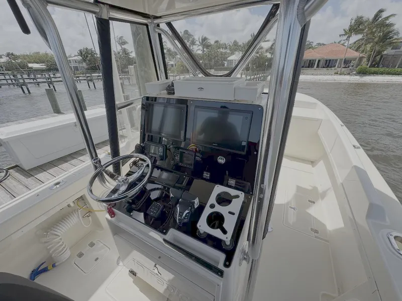 Slide: The Image of 2004 Intrepid 32 Cuddy boat cockpit with steering wheel and navigation equipment. - 12