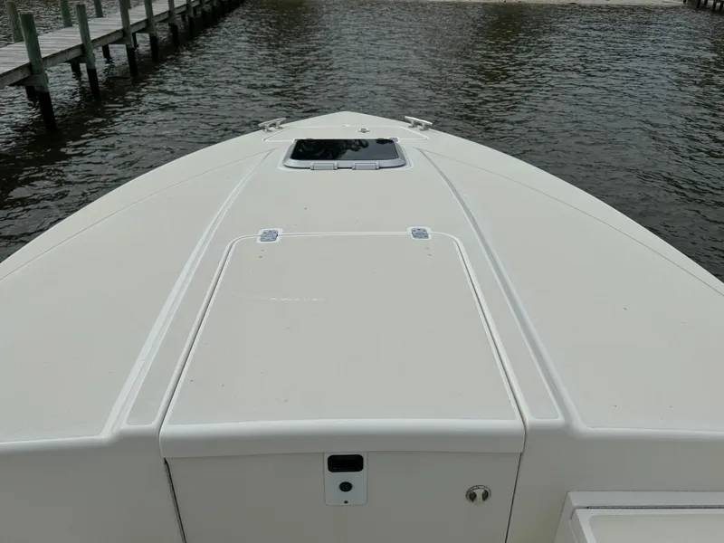 Slide: The Image of 2004 Intrepid 32 Cuddy boat bow view on water near dock. - 17