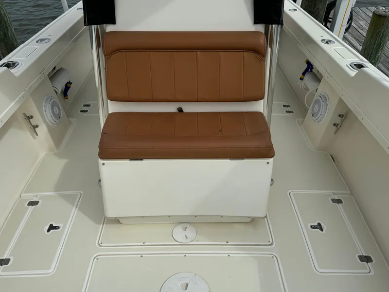 Slide: The Image of 2004 Intrepid 32 Cuddy boat interior with tan seating and storage compartments. - 19