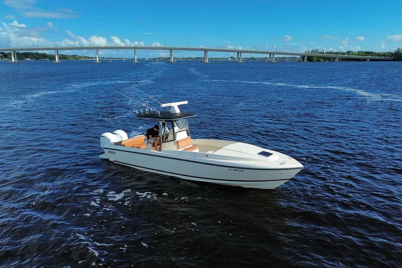 Slide: The Image of 2004 Intrepid 32 Cuddy boat on open water with bridge in background. - 2
